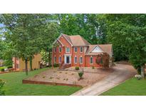 Stately two-story brick home with a well-manicured front yard and mature trees at 1952 Skidmore Cir, Lawrenceville, GA 30044