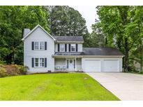 Charming two-story home with white siding, black shutters, a cozy front porch, and an attached two-car garage at 2093 Kolb Ridge Sw Ct, Marietta, GA 30008