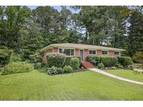 Charming brick home featuring a well-manicured lawn and lush landscaping at 388 Talcott Nw Cir, Marietta, GA 30064