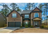Charming two-story brick home featuring an attached two-car garage and covered front entrance at 9941 Musket Ridge Cir, Jonesboro, GA 30238