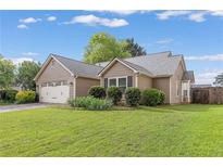 Charming single-story home with well-manicured lawn and attached two-car garage at 1615 Nw Vinebrook Nw Ter, Kennesaw, GA 30144