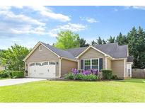 Charming single-story home with a well-manicured lawn and a lovely flower bed in the front yard at 1615 Nw Vinebrook Nw Ter, Kennesaw, GA 30144
