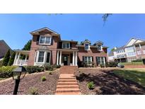 Elegant brick home with manicured landscaping and a welcoming front porch at 4541 Meadow Club Dr, Suwanee, GA 30024