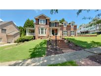 Beautiful two-story brick home with meticulously maintained front yard and grand entrance with brick steps at 4541 Meadow Club Dr, Suwanee, GA 30024