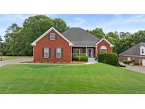 Charming brick home boasts a well-manicured lawn and inviting front porch at 9507 Greens Mill Ct, Loganville, GA 30052