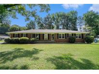 Charming brick home with lush front lawn and meticulously maintained landscaping at 1663 Pounds Sw Rd, Stone Mountain, GA 30087