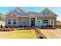 Beautiful brick home with manicured lawn and colorful flowerbeds enhances curb appeal at 1278 Hollingsworth Way, Dacula, GA 30019