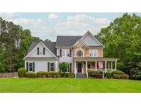 Charming two-story home with stone accents, a welcoming front porch, and a lush green lawn at 6610 Major Dr, Cumming, GA 30040