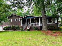 Charming home with a welcoming front porch and well-maintained lawn at 942 Batesville Rd, Canton, GA 30115