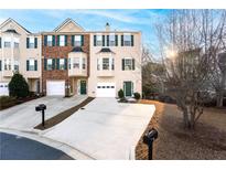Charming townhome featuring a one car garage, green shutters, and bay windows, creating a welcoming curb appeal at 805 Abbotts Mill Ct # 74, Duluth, GA 30097
