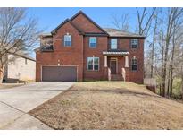 Charming two-story brick home features a two-car garage and a well-manicured lawn at 3313 Alhambra Cir, Hampton, GA 30228