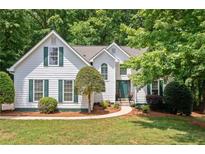 Charming two-story home with green shutters and lush, mature landscaping at 2605 Woodland Hills Dr, Cumming, GA 30040