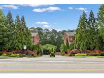 A gated townhome community with mature trees, well-maintained landscaping and brick signage at 4298 Kingston Gate Cv, Chamblee, GA 30341