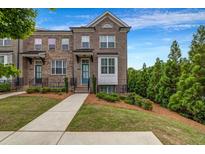 Brick townhome with manicured lawn, landscaping and a walkway leading to the front door at 4565 Sims Park Ovlk, Suwanee, GA 30024