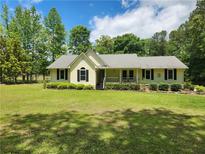 Charming single-story home with a manicured lawn and a welcoming front porch at 350 Lakeview Dr, Brooks, GA 30205