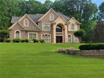 Stunning two-story brick home with arched windows and a meticulously manicured lawn at 45 Mountain Crest Dr, Oxford, GA 30054