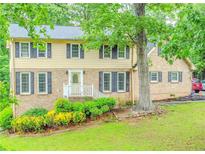 Charming two-story home with brick and vinyl siding and a well-manicured lawn and lush landscaping at 5293 Sandy Shoals Ln, Stone Mountain, GA 30087