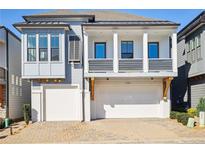 Beautiful two story home features brick driveway, dual garages, and charming balcony at 114 Village Green Ave, Woodstock, GA 30189