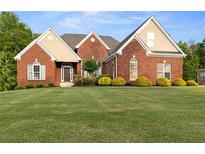 Beautiful single Gathering home featuring a well-manicured lawn and classic brick exterior at 150 Rose Creek Dr, Covington, GA 30014