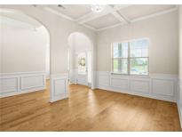Bright living room featuring hardwood floors, wainscoting and an arched entryway at 321 Shannon Ct, Mcdonough, GA 30252