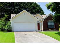 Charming home featuring a two-car garage, brick accents, and a well-maintained lawn at 965 Under Ct, Sugar Hill, GA 30518