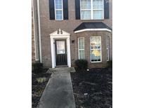 Charming brick home featuring a classic front door with decorative trim and a well-maintained front yard at 1843 Grove Way, Hampton, GA 30228