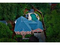 Stunning aerial view of a brick home featuring a beautiful pool and lush landscaping at 2882 Clary Hill Ne Dr, Roswell, GA 30075