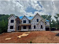 New construction home featuring blue roof, covered porch and views of a wooded lot at 2808 Carson Garrett Ct, Buford, GA 30519