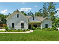 Charming one-story home with a well-manicured lawn, lush landscaping, and a welcoming front porch at 3445 Henderson Dr, Cumming, GA 30041