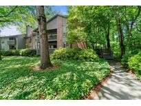 Condominium building featuring lush landscaping and a sidewalk leading to the entrance at 1424 Tuxworth Cir, Decatur, GA 30033