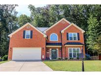 Charming red brick home with manicured lawn, black shutters, and a two-car garage at 1890 Turtle Creek Way, Lawrenceville, GA 30043