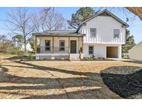 Charming two-story home with a cozy covered porch and modern, white brick and wood detailing at 1382 Bennett Rd, Grayson, GA 30017