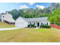 Charming single-story home with a well-manicured lawn, attached garage, and inviting front entrance at 2221 Baker Carter Dr, Loganville, GA 30052