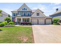 Charming two-story home featuring a three-car garage, manicured lawn and lush landscaping at 337 Spotted Ridge Cir, Woodstock, GA 30188