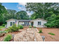 Charming single-story home featuring a stone walkway, lush landscaping, and inviting front porch at 2184 E Cherokee Dr, Woodstock, GA 30188