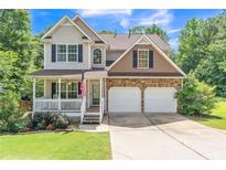 Charming two-story home with a well-maintained lawn, stone accents, and a welcoming front porch at 329 Kyles Cir, Hiram, GA 30141