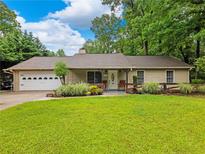 Charming single-story home with a lush green lawn and mature trees providing ample shade at 2956 Springlake Dr, Buford, GA 30519