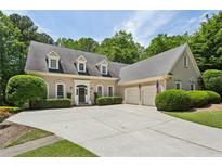 Charming home featuring a spacious driveway, manicured lawn, and a symmetrical facade at 4070 Ridgehurst Se Dr, Smyrna, GA 30080