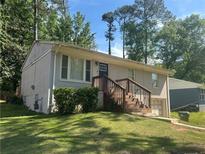 Charming grey-painted brick home with a front yard and wood porch steps at 115 Delmoor Nw Dr, Atlanta, GA 30311