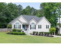Charming home with a well-manicured lawn, blue door, fresh landscaping, and black shutters at 128 Champion Way, Hiram, GA 30141