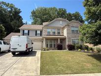 Charming two-story home with brick and gray siding, well-maintained landscaping, and a spacious driveway at 139 Vinca Cir, Suwanee, GA 30024