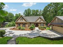 Charming home showcasing stone accents, manicured landscaping, and an inviting driveway at 2945 Ashbyrn Ct, Buford, GA 30519