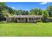 Charming brick home with a cozy front porch and a spacious green lawn at 315 Pleasant Grove Rd, Mcdonough, GA 30252