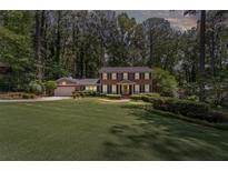 Beautiful two-story brick home with a well-manicured lawn, mature trees, and inviting curb appeal at 3287 Alton Rd, Atlanta, GA 30341