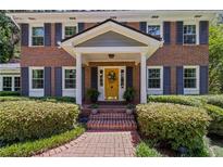 Charming brick home featuring a welcoming yellow front door with decorative wreath and manicured landscaping at 3287 Alton Rd, Atlanta, GA 30341
