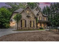 Stunning stone and brick home with a well-manicured lawn and a circular driveway at 3809 Wieuca Ne Rd, Atlanta, GA 30342