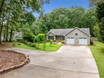 Charming single-story home featuring a well-manicured lawn and an inviting two-car garage at 5535 Dorsett Shoals Rd, Douglasville, GA 30135