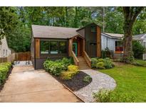 Charming home featuring a brown facade, inviting front porch, landscaped yard, and convenient driveway at 2001 Swazey Dr, Decatur, GA 30032