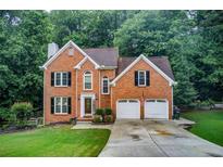Charming two-story brick home with a well-manicured lawn and attached two-car garage at 1360 Stampmill Way, Lawrenceville, GA 30043