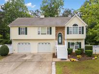 Charming home with a two-car garage, stone accents, and manicured landscaping at 1620 Cedar Hl, Douglasville, GA 30134